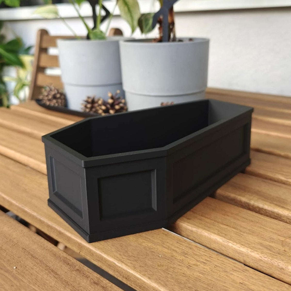Empty coffin planter on table, decorative gothic plant container
