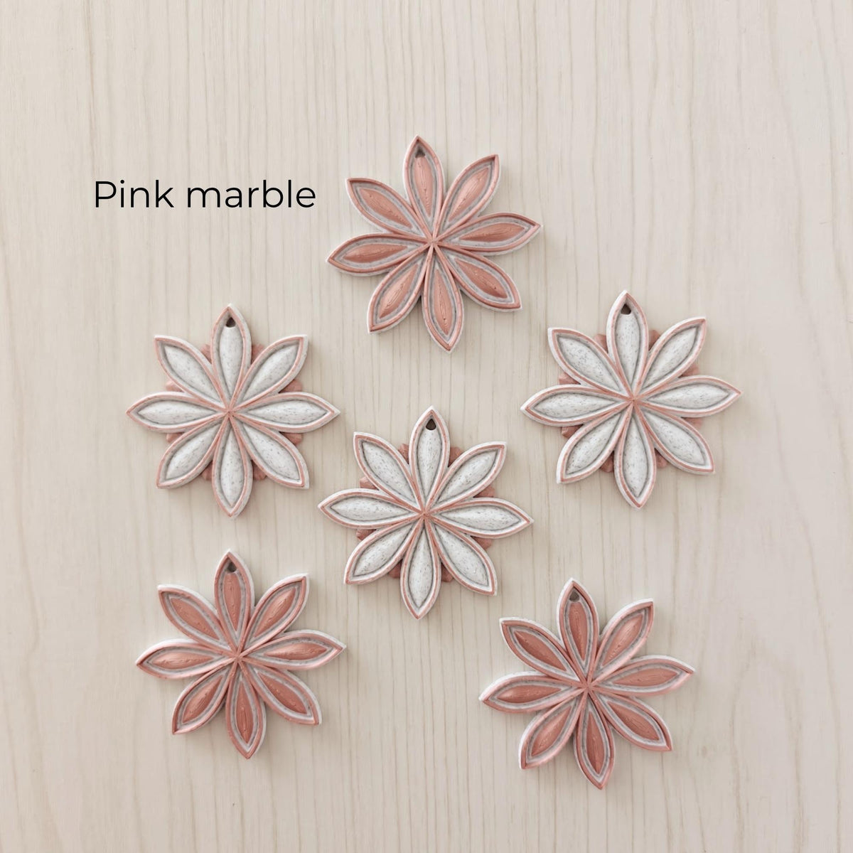 Pink marble star anise ornaments in soft pink, white and marble-effect color combinations.