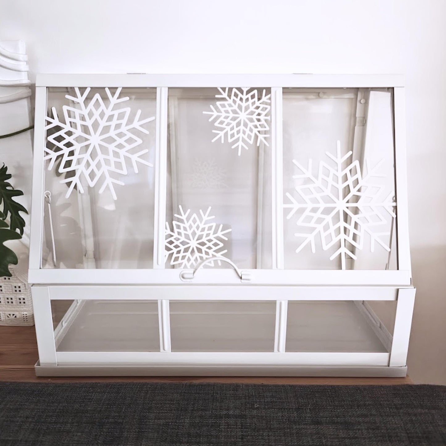 White Äkerbar greenhouse with 4 snowflake designs attached to the front panels.