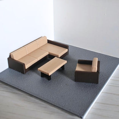 Living room diorama setup with sectional sofa and coffee table in 1:64 scale