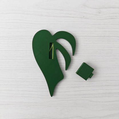 Back view of the handle showing the key slot opening, with the separate green cover piece placed beside it.