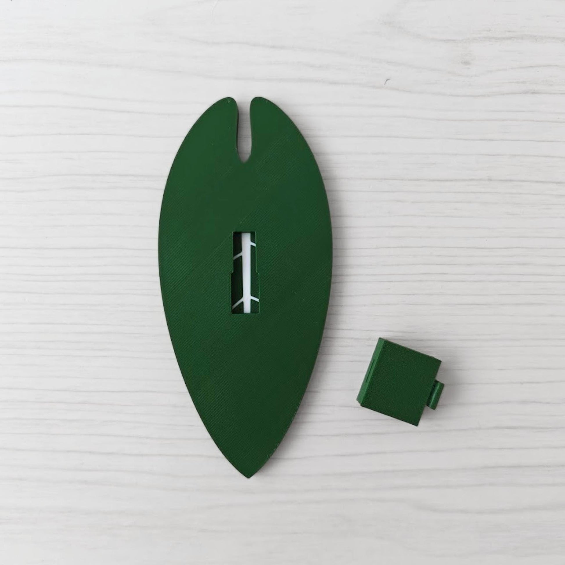 Back view of the handle with the separate green cover piece placed beside it.