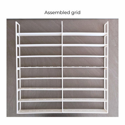 Fully assembled white LEGO minifigure grid insert shown outside the frame.