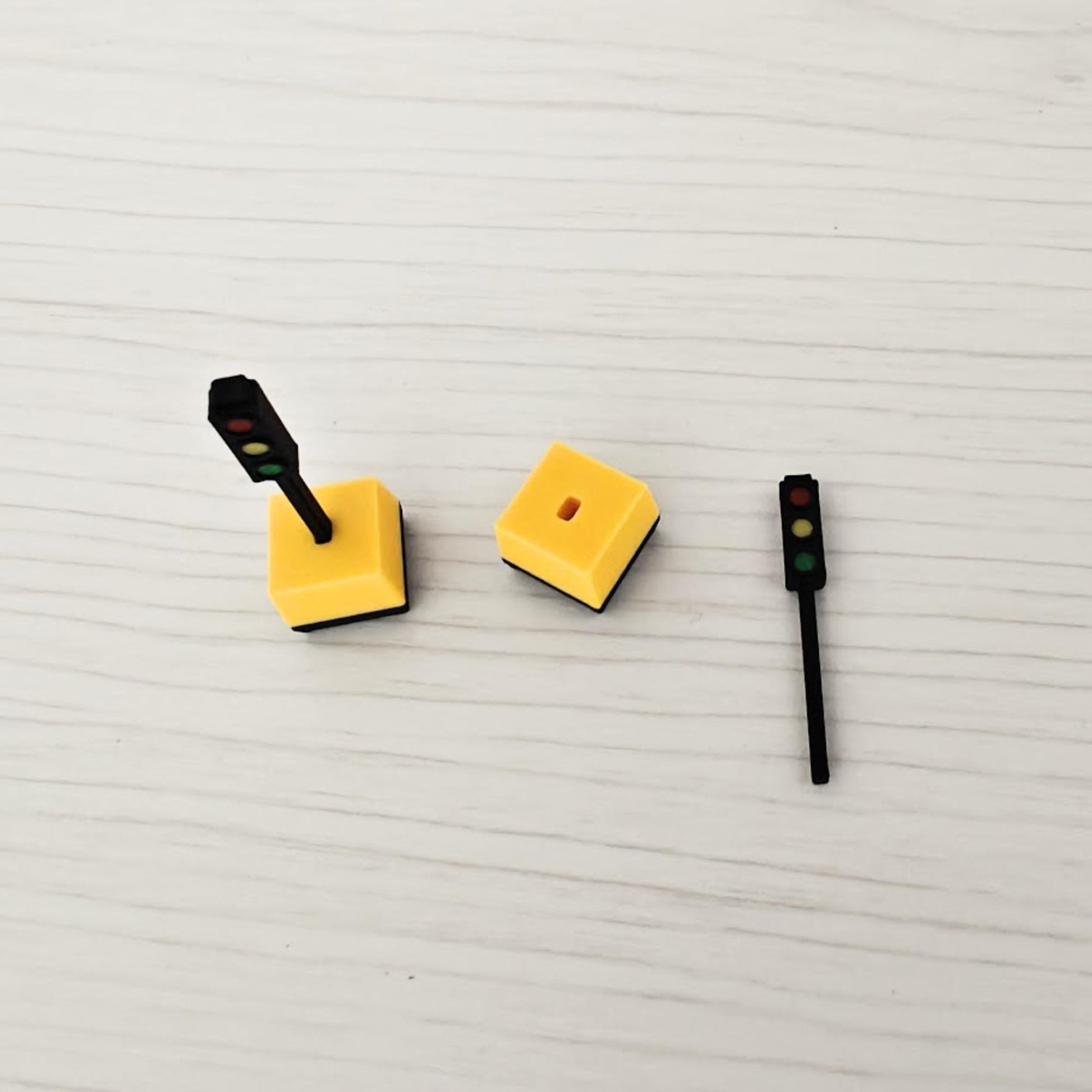 Disassembled 1/64 traffic light parts showing base and signal pole