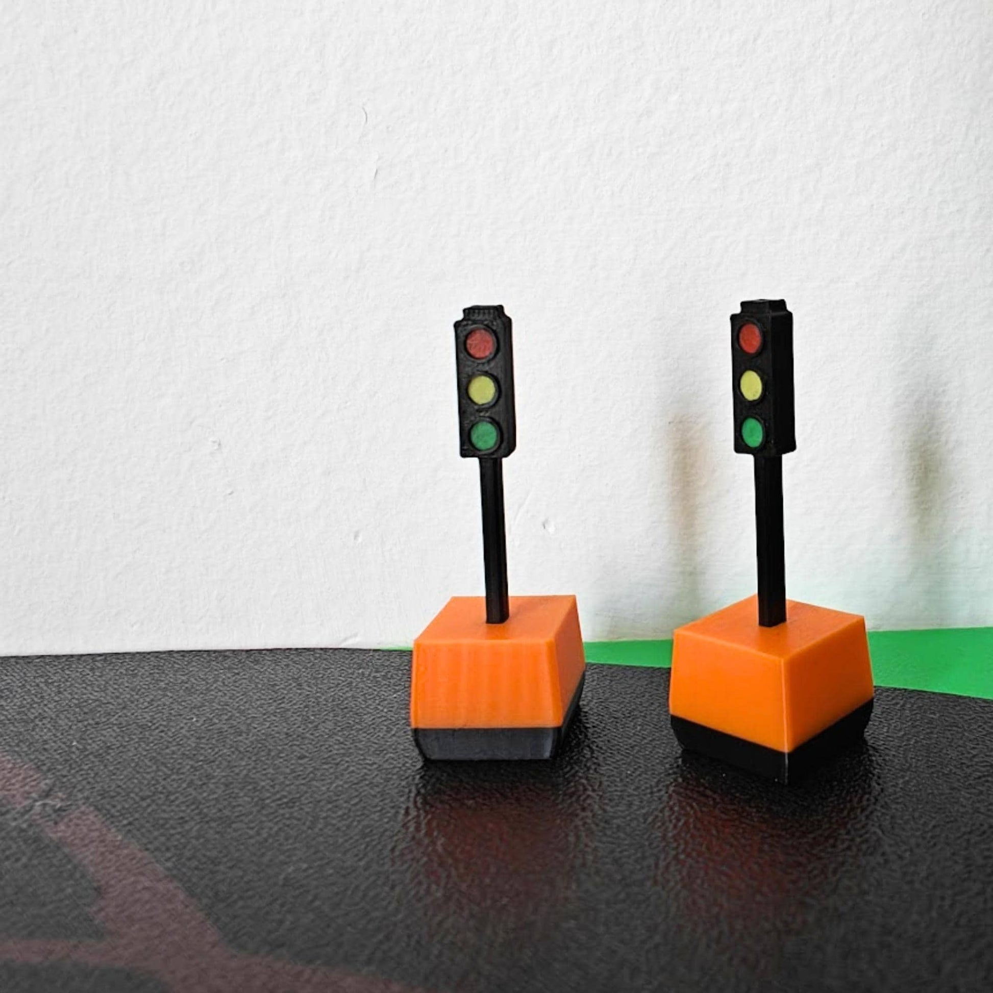 Pair of 1/64 traffic lights with orange bases on curved road display