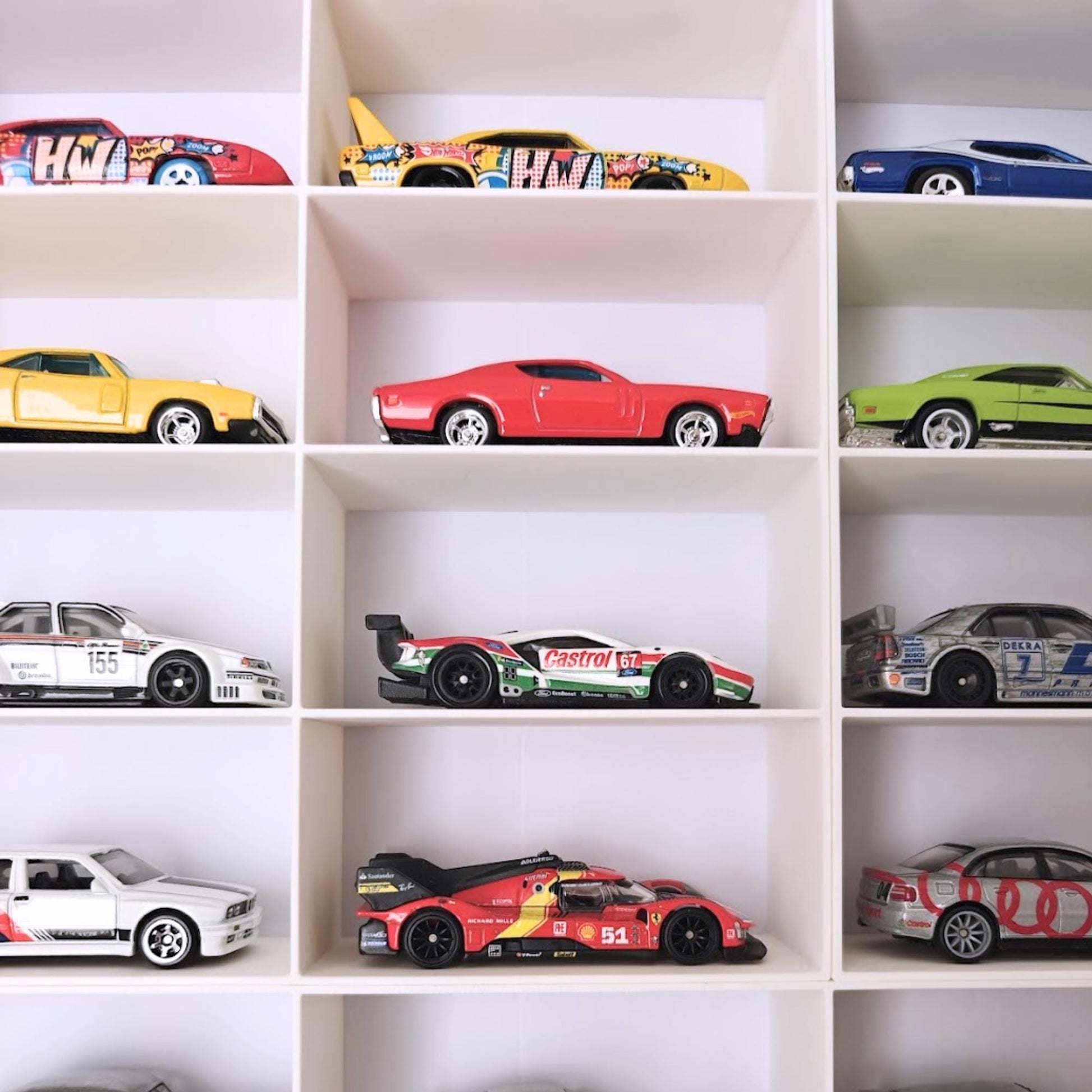 Close-up of Hot Wheels cars arranged in grid compartments