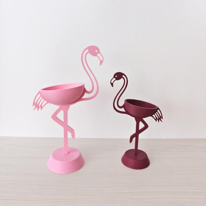 Pink and burgundy flamingo plant holders without plants on neutral background