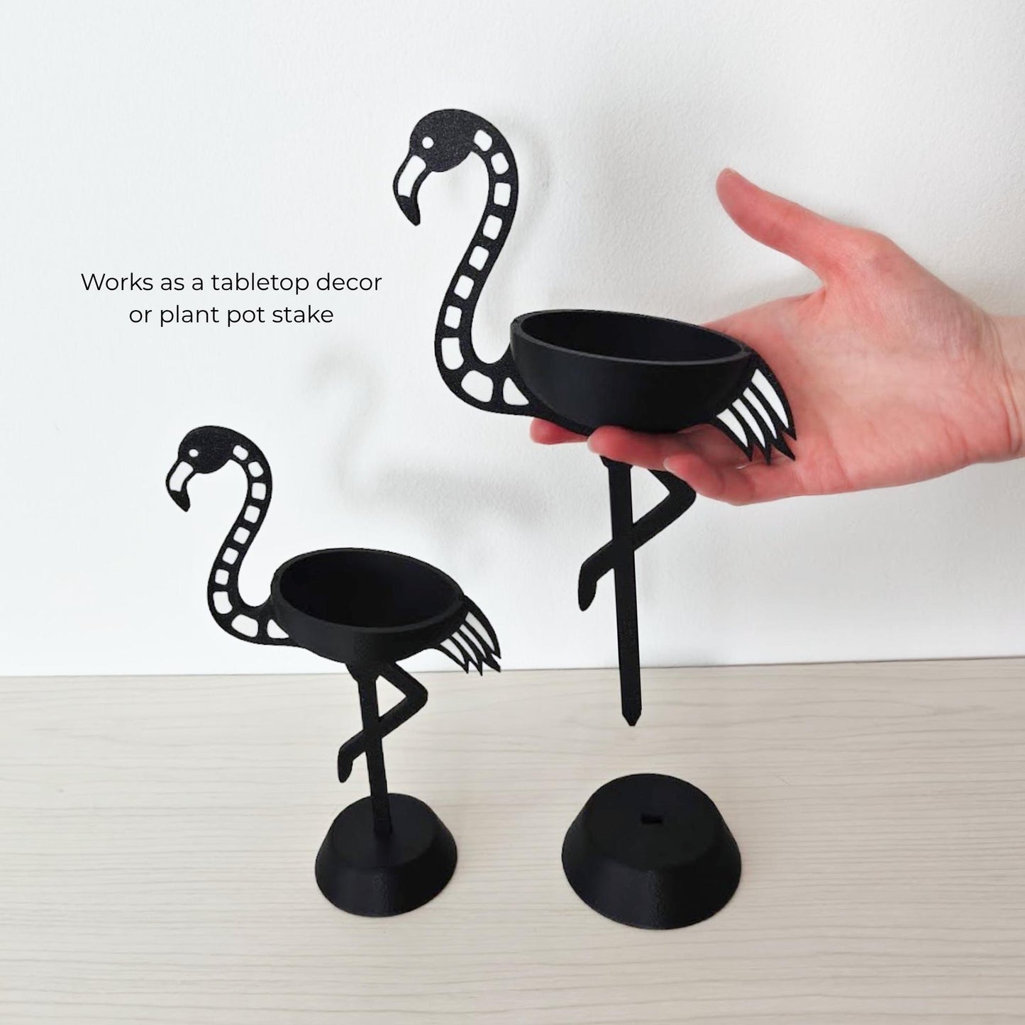 Hand holding small flamingo air plant holder showing that it can be also used as a planter stake