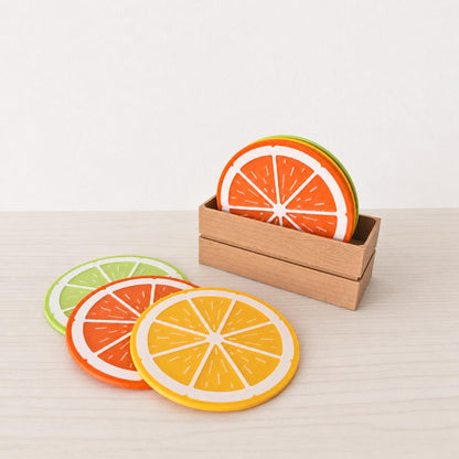 Citrus coaster set with lemon, orange and lime slice coasters displayed with a wooden crate holder on a light table.