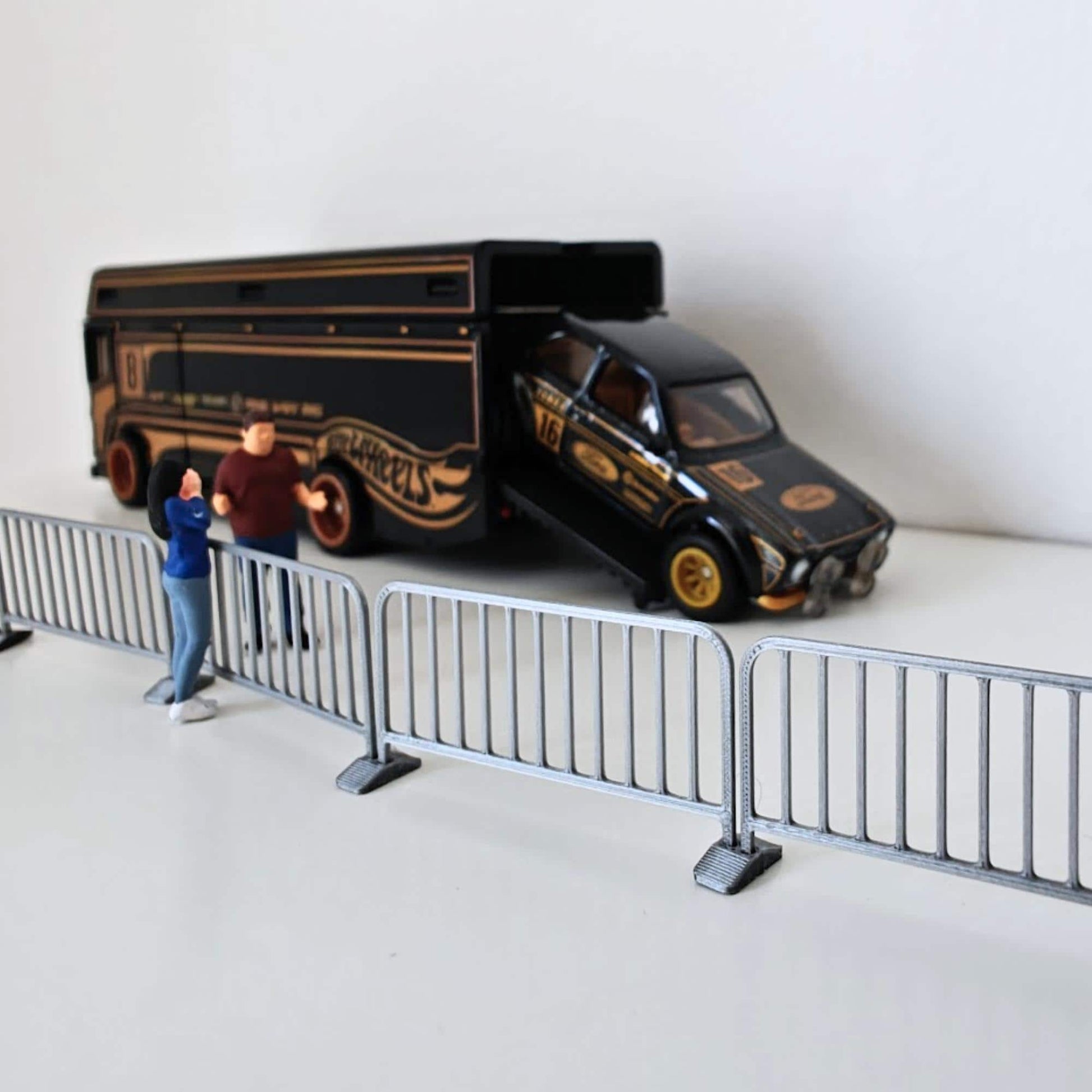 Miniature barricade fence line displayed in front of a black diecast van and small figures.