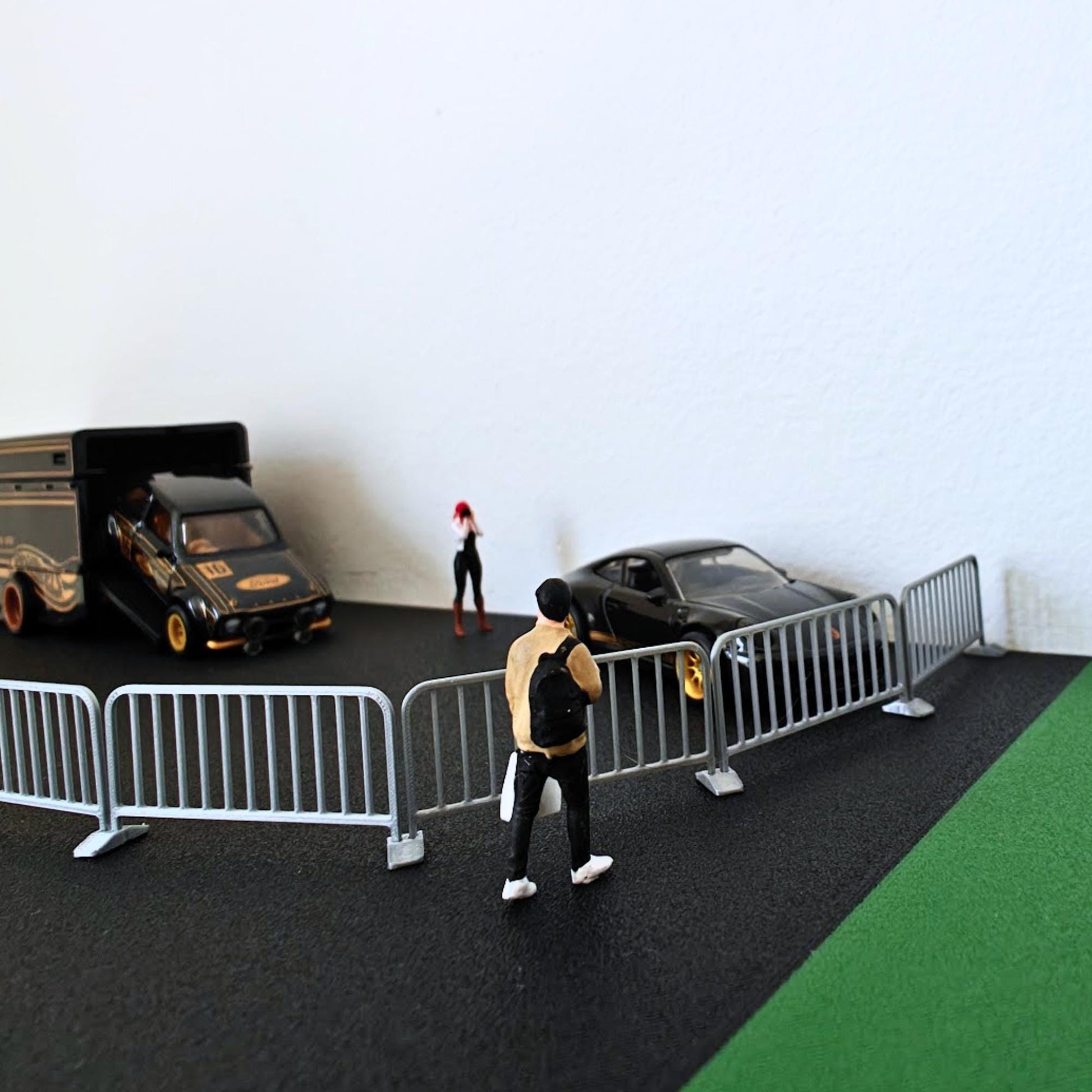 Mini crowd control fence set used as a road barrier around a diecast car and miniature figures.