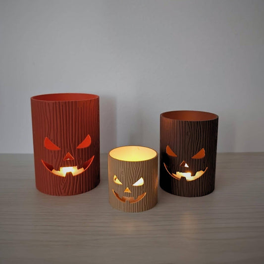 Halloween tree stump jack-o’-lantern holders glowing with LED tealights.