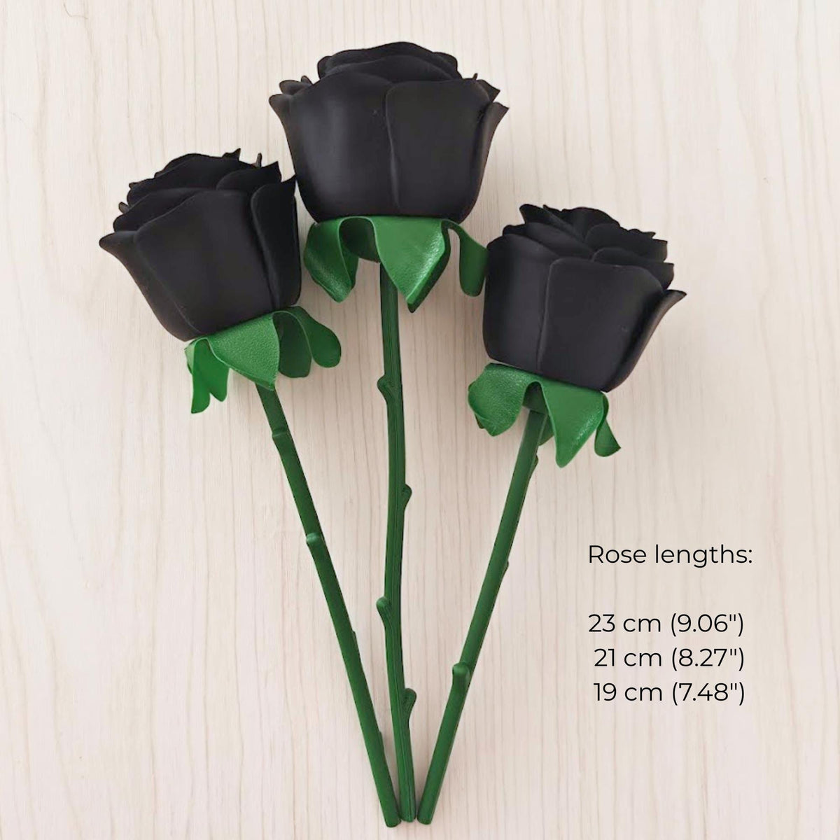 Three black faux roses with green stems in different lengths: 19 cm, 21 cm and 23 cm.