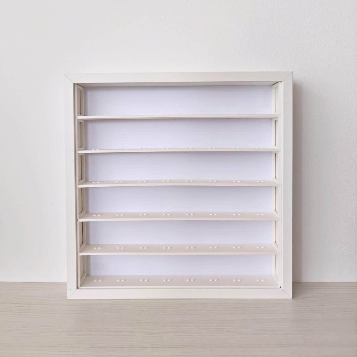 Front view of an empty white SANNAHED frame fitted with the six-row minifigure display insert.