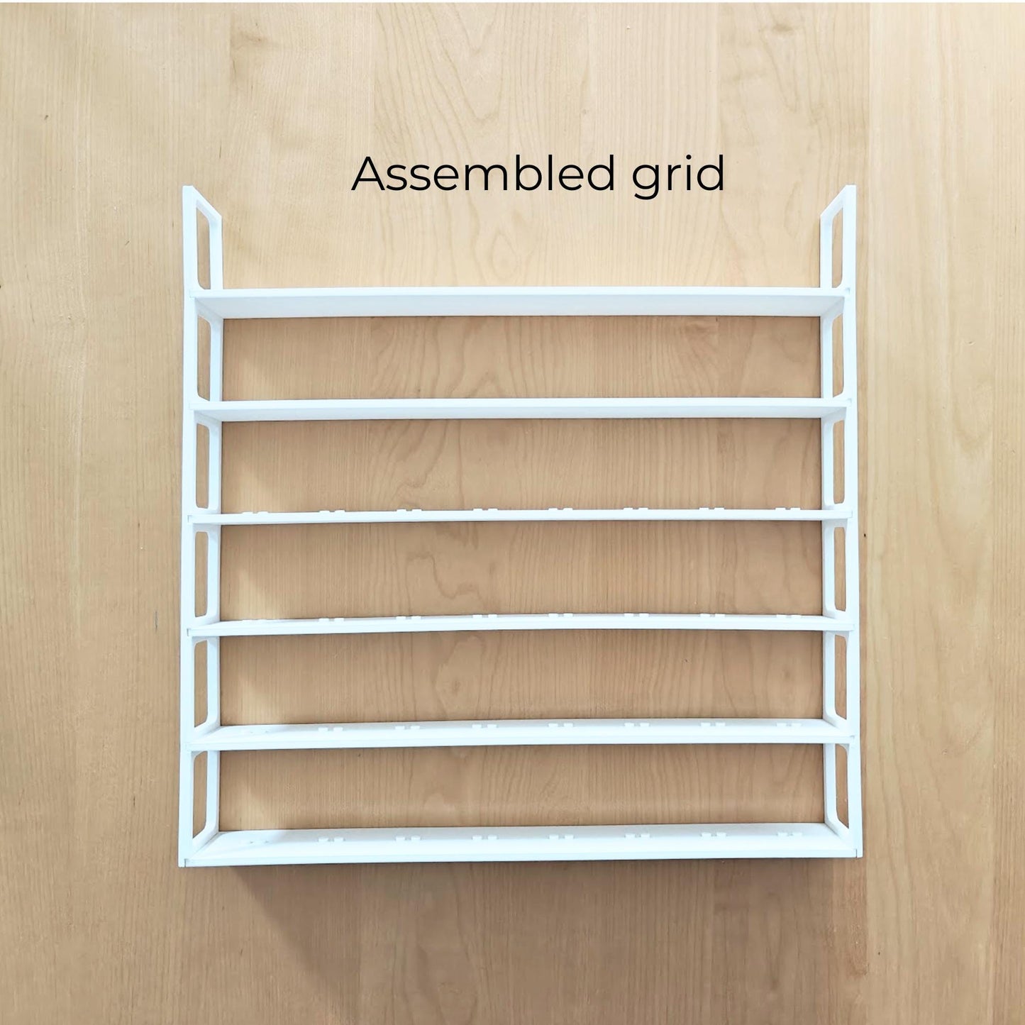 Fully assembled white six-row minifigure display grid shown outside the frame.
