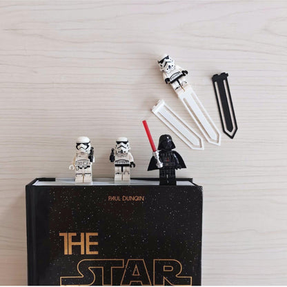 Brick-compatible minifigure bookmark clips displayed on a book with collectible figures