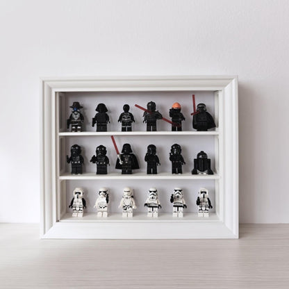 White horizontal VÄSTANHED frame insert displaying black and white LEGO minifigures across three shelves.
