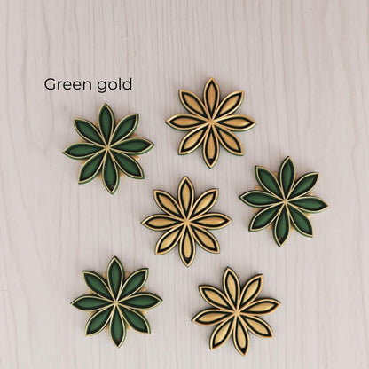 Green and gold star anise ornaments in dark green, black and gold color combinations.