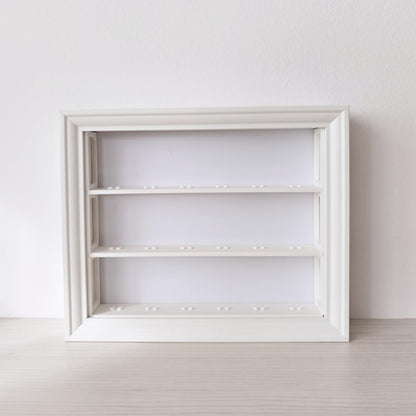 Front view of empty horizontal VÄSTANHED frame insert with three white display shelves.