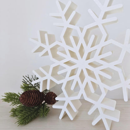 Close-up of large white snowflake Christmas decoration with pinecones and greenery