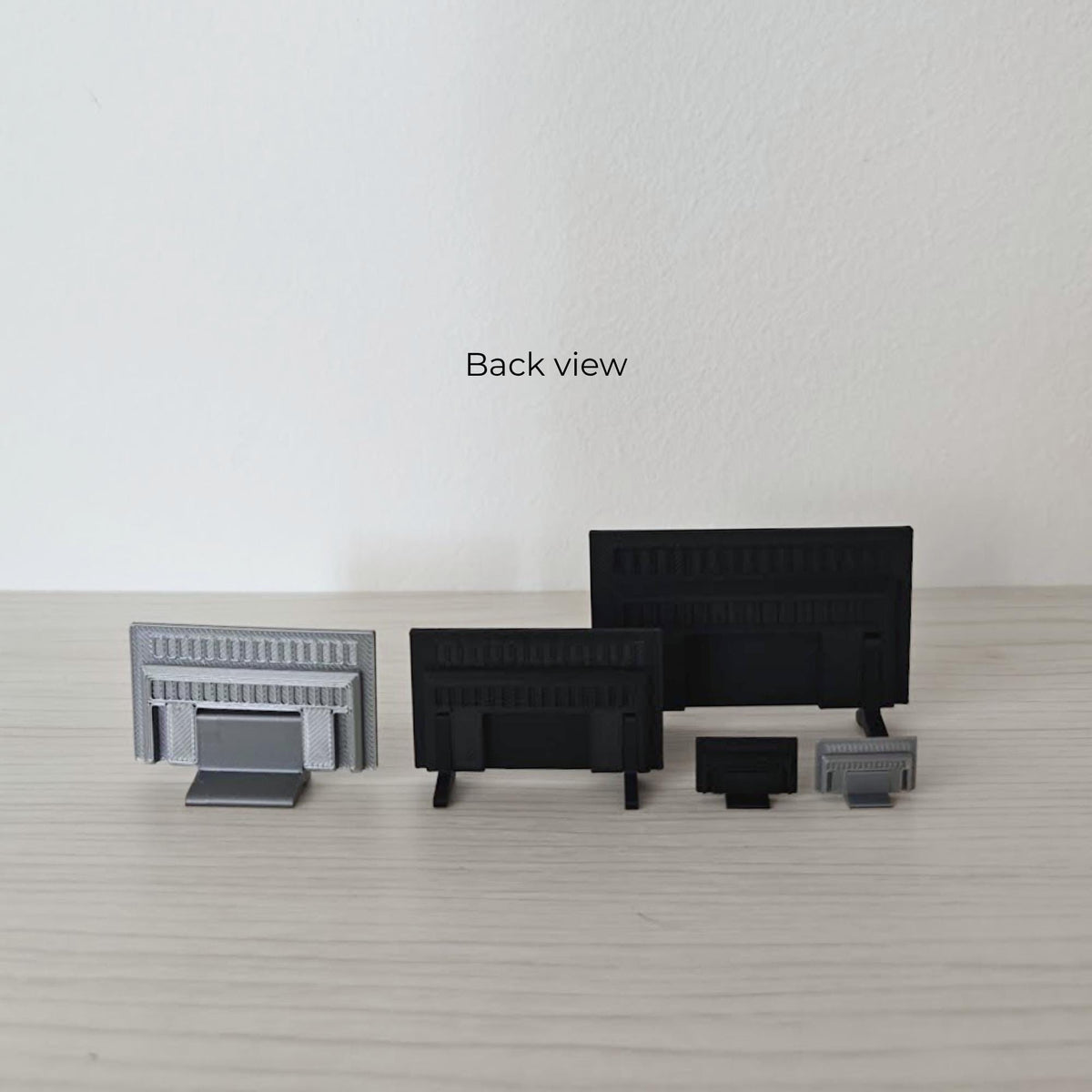 Back view of miniature TVs and stands showing the different support and leg designs.